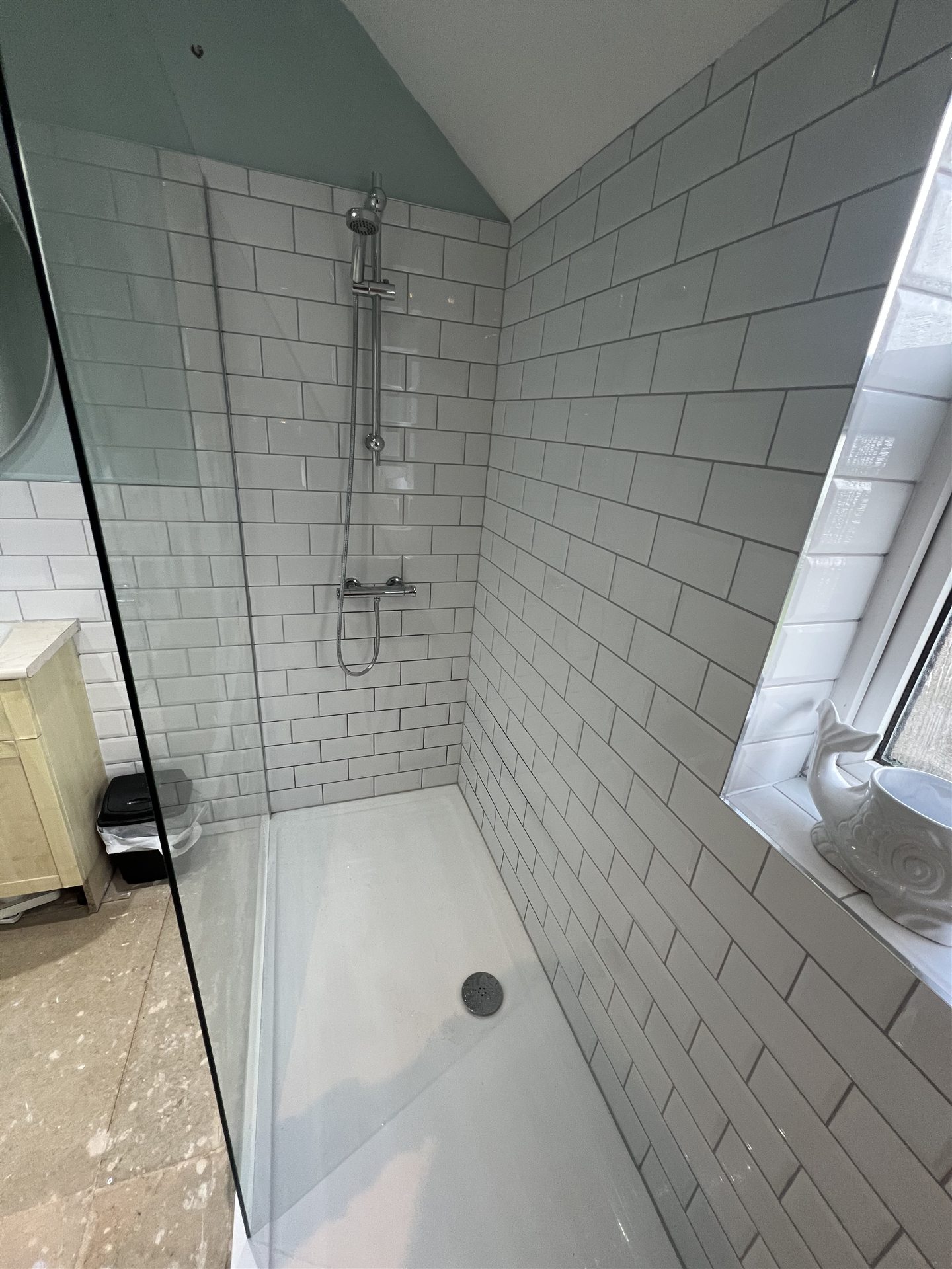 White metro tile walk-in shower with glass screen