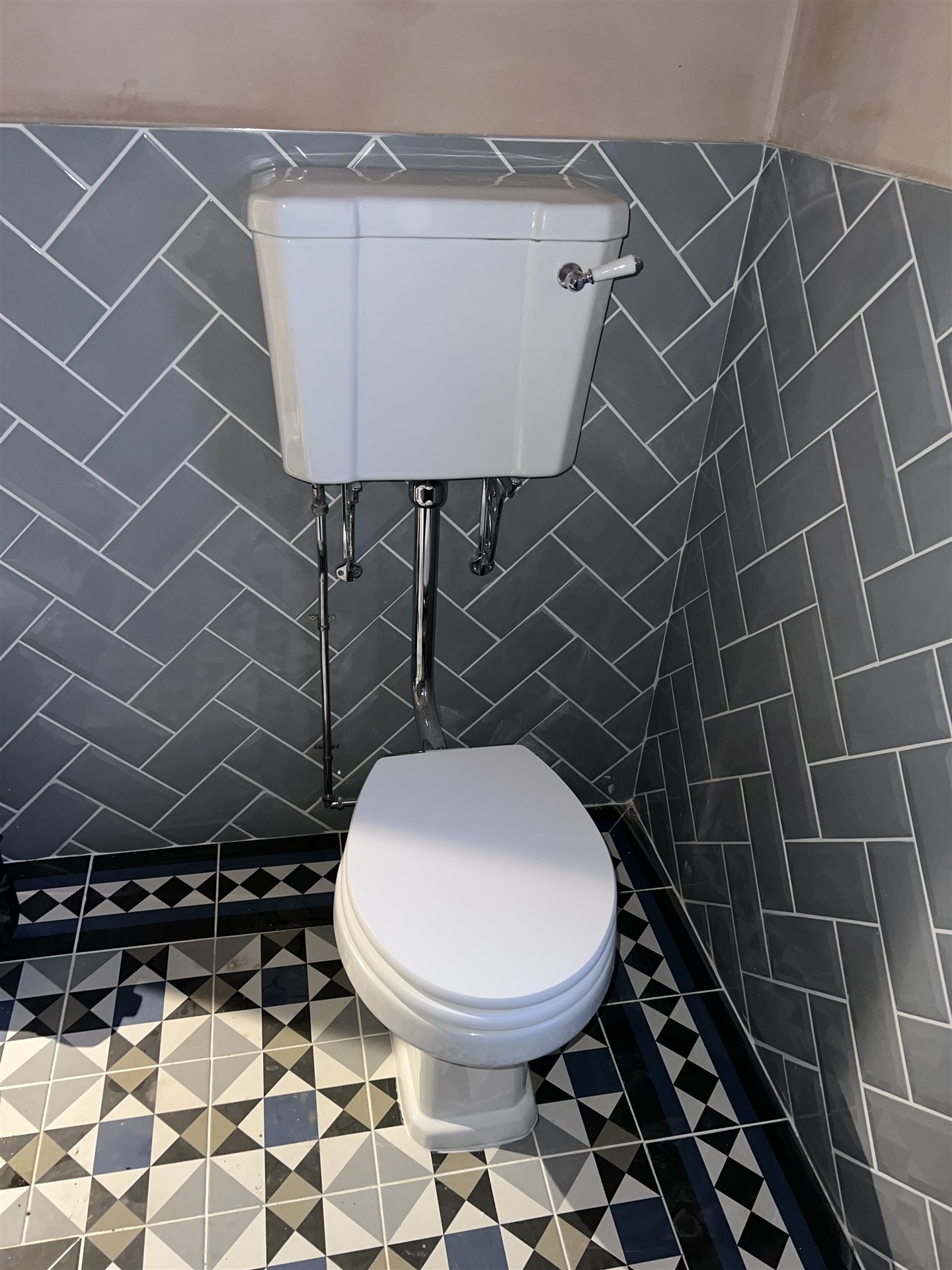 Herringbone tile bathroom, high-level cistern toilet, Victorian-style patterned floor